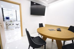 Αίθουσα αναμονής με στρογγυλό τραπέζι και τηλεόραση