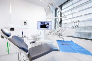 Αίθουσα θεραπείας με σύγχρονη οδοντιατρική καρέκλα και οθόνη